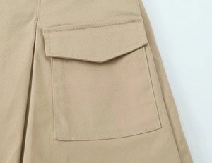 Detailed macro view of khaki cotton twill fabric with functional cargo flap pocket