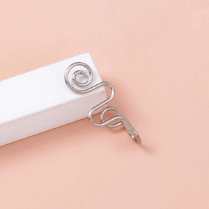 Close-up of a silver U-shaped nose ring with unique spiral wave design on a stand