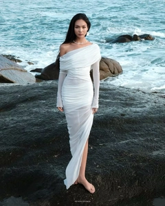 Detail of white one-shoulder mesh dress with elegant ruched texture and sheer fabric