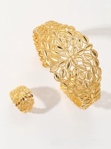 Detail of gold-plated leaf pattern hollow jewelry set including open bangle and matching ring