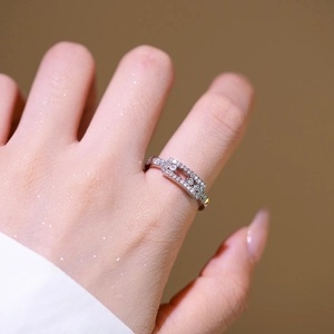 Silver wide band sliding ring with three moving diamonds worn on a finger