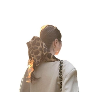 Leopard print fabric hair scarf tied on a low ponytail for a stylish retro look
