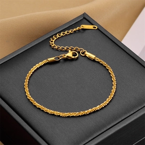 Elegant gold twisted chain bracelet on a black jewelry box with silk background