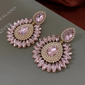 Macro de boucles d'oreilles gouttes en cristal rose avec design soleil vintage doré