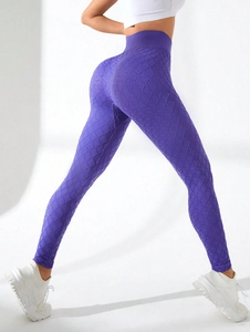 Macro detail of high-waist yoga leggings showing 3D textured honeycomb fabric in purple