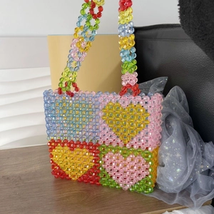 Macro detail of colorful beaded tote bag featuring a checkered heart pattern design