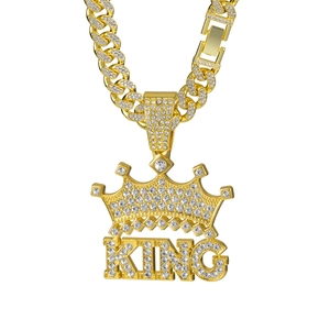 Gold plated Cuban chain necklace with iced out KING crown pendant on white background