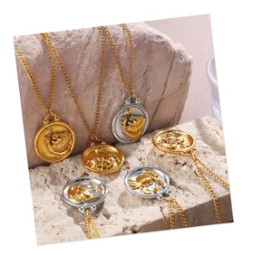 Macro shot of gold and silver zodiac relief pendants on textured beige stone