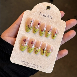 Detail of 10pcs almond press-on nails with bee and ladybug designs with pearls