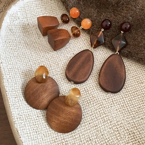 Detailed view of wood and resin geometric drop earrings with natural textures and amber tones