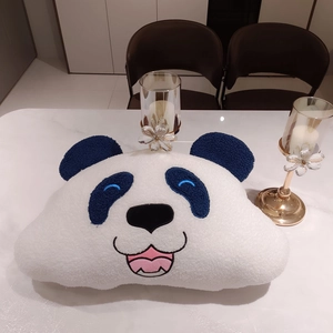 Close-up of cute panda plush pillow made of white fluffy fleece with embroidered eyes