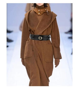 Close-up of wide black leather corset belt with gold square buckle on a brown wool coat