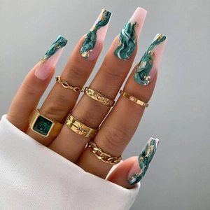 Detailed view of pink and green marble coffin nails with gold foil accents and gold rings