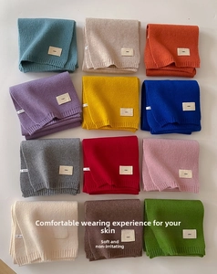 Detail view of 12 vibrant colors for the soft knit scarf with minimalist woven labels