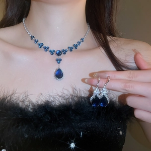 Detail of silver jewelry set with blue water-drop pendants and flower-shaped crystals