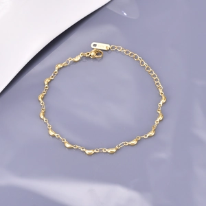 Macro shot of gold-plated bean chain bracelet with adjustable lobster clasp and K18 tag