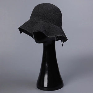 Detailed close-up showing the wavy edge and black knit texture of the foldable straw hat