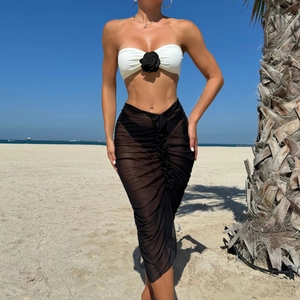 Close-up of white bandeau bikini top with a 3D black rose and a sheer mesh midi skirt