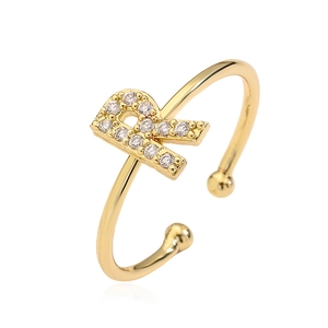 Detailed close-up of golden open ring featuring a sparkling zircon-encrusted letter R