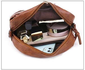 Vue de dessus du sac bandoulière en cuir marron avec compartiments et détails de zip