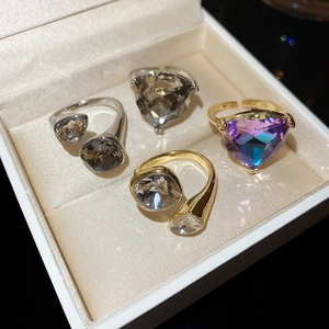 Close-up of assorted geometric crystal rings with triangle and oval stones in a jewelry box