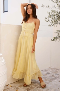 Gros plan d'une robe d'été jaune pâle avec volants délicats et texture de mousseline plissée