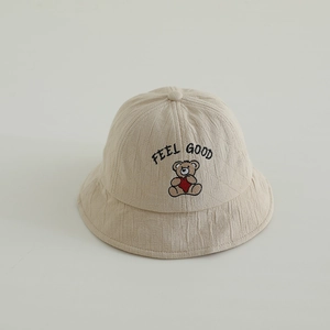 Close-up of beige cotton linen bucket hat featuring bear embroidery and Feel Good text