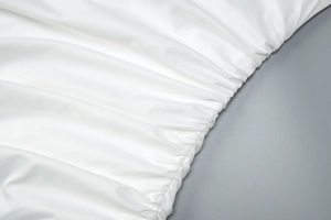 Detailed macro view of white ruched fabric texture on a backless summer dress
