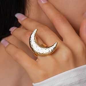 Close-up of golden moon ring with hammered texture on hand for a bohemian style