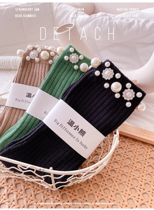 Detail of ribbed knit crew socks featuring elegant pearl and rhinestone flower embellishments