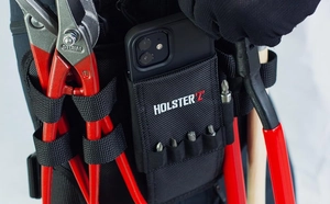 Close-up of durable Oxford fabric tool pouch worn on belt holding pliers and smartphone