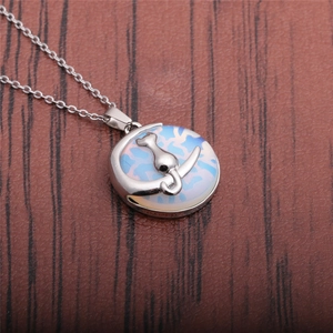 Detail of silver crescent moon and cat pendant on translucent blue opal stone