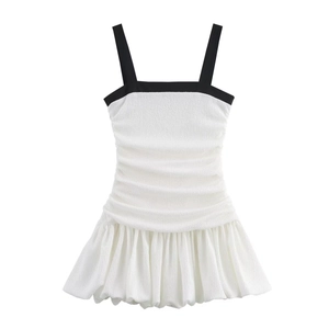Detail of black and white contrast dress with textured pleats and ruffled hemline