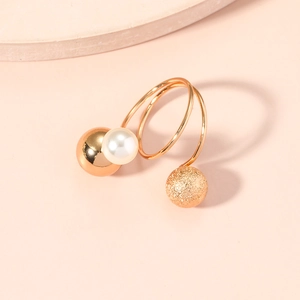Detail view of gold spiral ring with metallic spheres and white imitation pearls