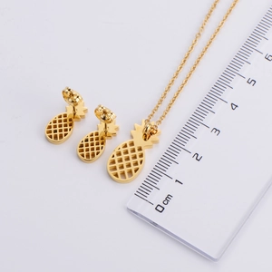 Golden titanium steel pineapple jewelry set with necklace and earrings on white background