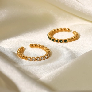 Close-up of 18K gold plated beaded open rings with white and green zircon on silk