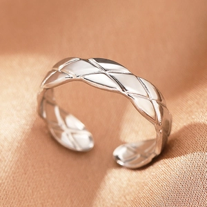 Detailed close-up of bohemian silver ring featuring quilted rhombus patterns on silk