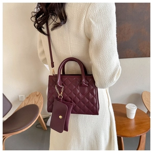 Detail of burgundy quilted shoulder bag with small coin purse and gold hardware