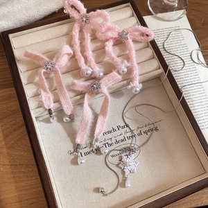 Detailed view of pink bow earrings and snowflake necklace with pearls in a gift box