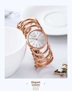 Detail of rose gold bracelet watch with unique hollow bangle design and white round dial