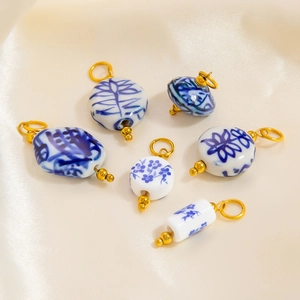 Detailed view of blue and white ceramic pendants on beige satin background