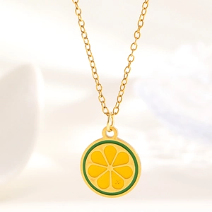Detail of a gold-plated lemon pendant necklace featuring vibrant yellow enamel fruit slice