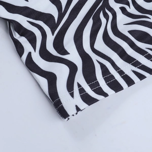 Gros plan macro d'un tissu à imprimé zèbre avec double couture précise et motif noir et blanc