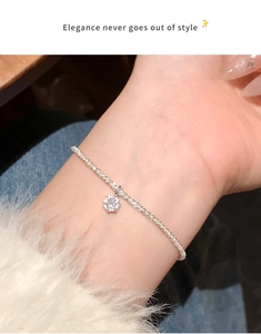 Primo piano di un bracciale d'argento con ciondolo a stella indossato con eleganza