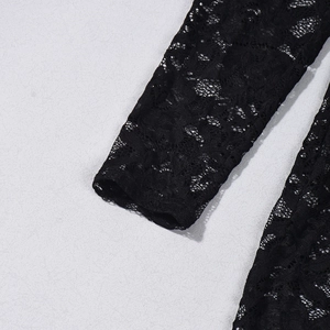 Close-up detail of black lace fabric and intricate floral pattern on a bodysuit