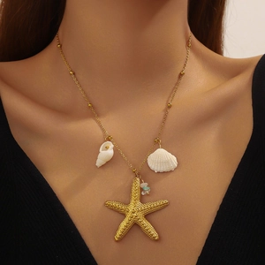 Gold starfish and white shell pendant necklace on a model for a beach vacation look