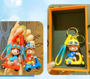Detail of cartoon boy and girl keychain set with gradient straps in a gift box