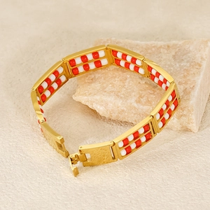 Close-up of double-row bead abacus bracelet in 18K gold finish with red and white beads