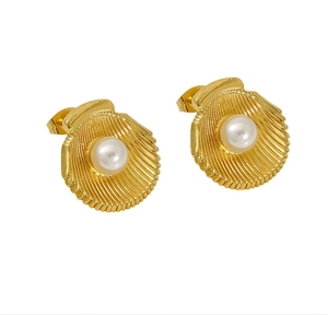 Macro detail of 18K gold plated shell earrings with elegant white pearl center