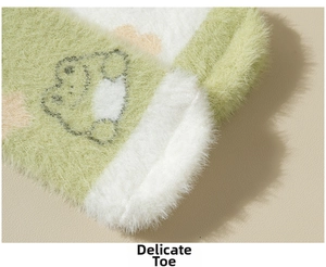 Detailed macro view of the cute green frog embroidery on plush thick fuzzy winter socks